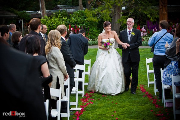 Suzy and her father walk down the aisle during her outdoor wedding with Michael at Kiana Lodge in Poulsbo, WA. (Photo by Andy Rogers/Red Box Pictures)