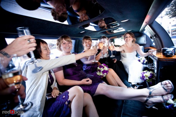 Lisa, Alex and their wedding party toast during a limousine ride from Pike Place Market prior to their wedding at the Edgewater Hotel. (Photo by Andy Rogers/Red Box Pictures)