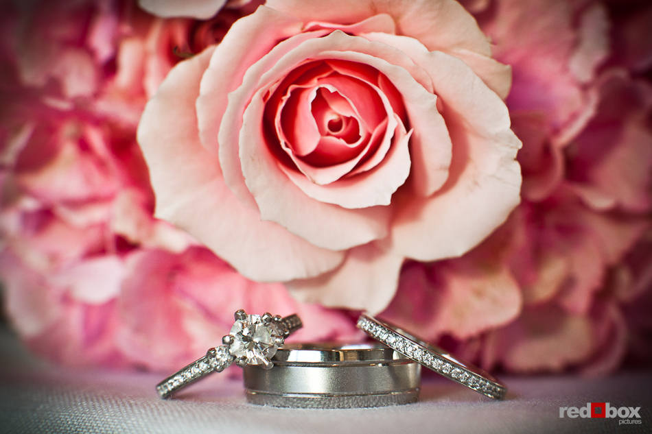 Nadine and Brian's wedding rings are photographed with flowers a the Plateau Club in Sammamish, WA, their reception venue. (Photo by Dan DeLong/Red Box Pictures)