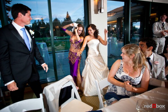 Nadine and a belly dancer show their technique during Brian and Nadine's wedding at the Plateau Club in Sammamish is the reception venue. (Photo by Dan DeLong/Red Box Pictures)