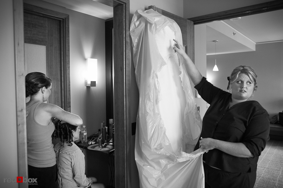 Mary removes her wedding dress from its bag while getting ready for her Seattle Aquarium wedding at the Grand Hyatt Seattle. (Photography by Andy Rogers/Red Box Pictures)