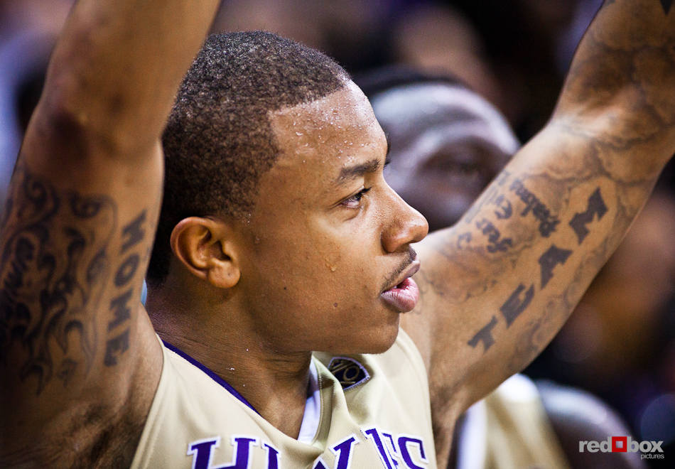 Washington Huskies' Isaiah Thomas displays his tattoos while cheering on teammates from the bench during the men's basketball season opener against McNeese State at UW's Hec Edmundson Pavilion. (Photo by Dan DeLong/Red Box Pictures)