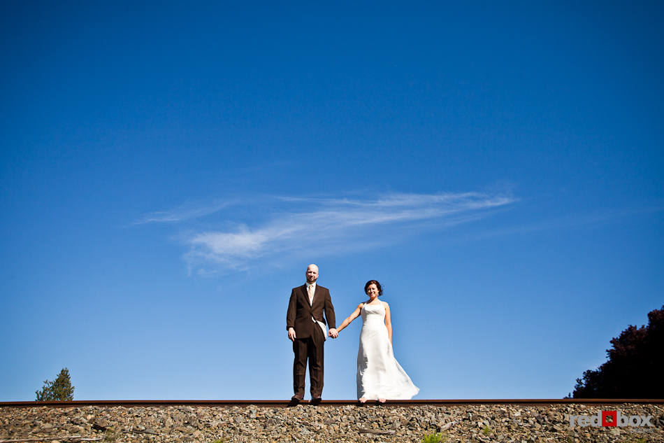 Liz and Ted are photographed against a brilliant blue sky before being married at Hidden Meadows in Snohomish, WA. (Photo by Dan DeLong/Red Box Pictures)
