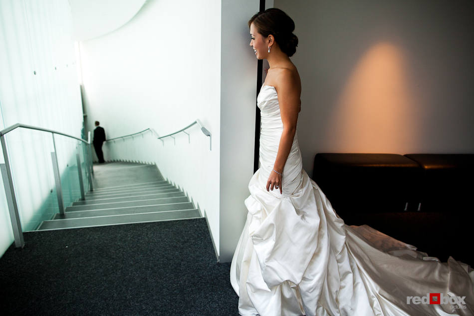 Nora peeks at Neill during their first look before their wedding at the Bellevue Art Museum. (Photo by Dan DeLong/Red Box Pictures)