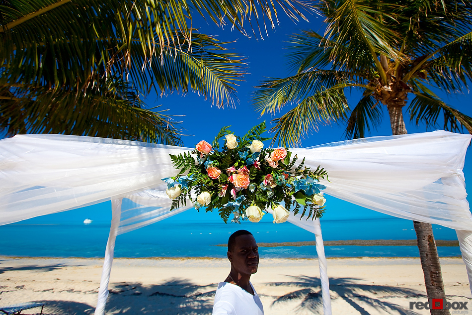 The florist works on the flowers for the arch at the Old Bay Bahama Resort in the Bahamas. (Wedding Photography by Scott Eklund/Red Box Pictures)