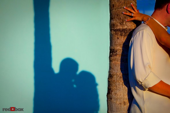 The bride & groom kiss under a palm tree at the Old Bay Bahama Resort in the Bahamas. (Wedding Photography by Scott Eklund/Red Box Pictures)