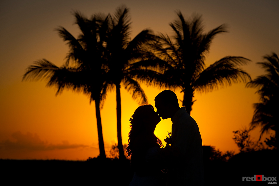 The bride & groom kiss on the beach at sunset at their wedding at Old Bay Bahama Resort in the Bahamas. (Wedding Photography by Scott Eklund/Red Box Pictures)
