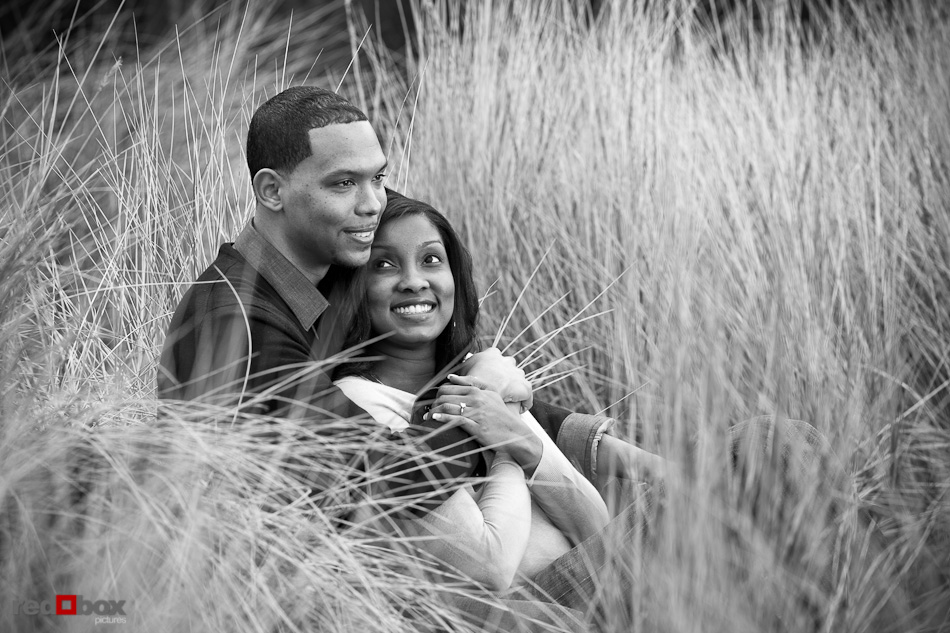 Nick and Tia talk in the tall grass at Seacrest Park in West Seattle for their engagement portrait photos. (Photography by Andy Rogers/Red Box Pictures)