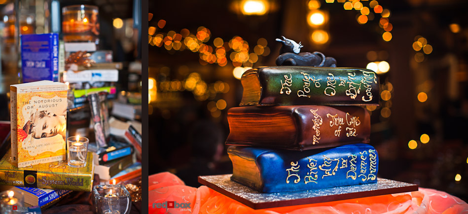 Wedding cake is shaped like stacked books with a cat reclining on top. Table top display features books that guests could choose to bring home with them. (Photo by Andy Rogers/Red Box Pictures)