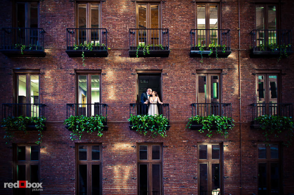 Bride Katie and groom Bryce greet their guests from the window above the Court in the Square in Seattle's Pioneer Square. (Photo by Dan DeLong/Red Box Pictures)