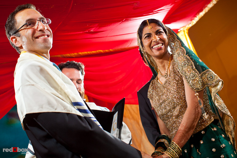 Mike and Karthik smile at their guests during their Jewish wedding ceremony at the Uptown Hideaway in Seattle. (Photography by Dan DeLong/Red Box Pictures)