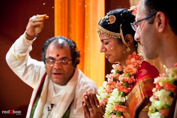 Pundit Mahesh Shastri tosses rice toward Karthik and Mike during their Indian wedding ceremony at the Uptown Hideaway in Seattle. (Photography by Andy Rogers/Red Box Pictures)
