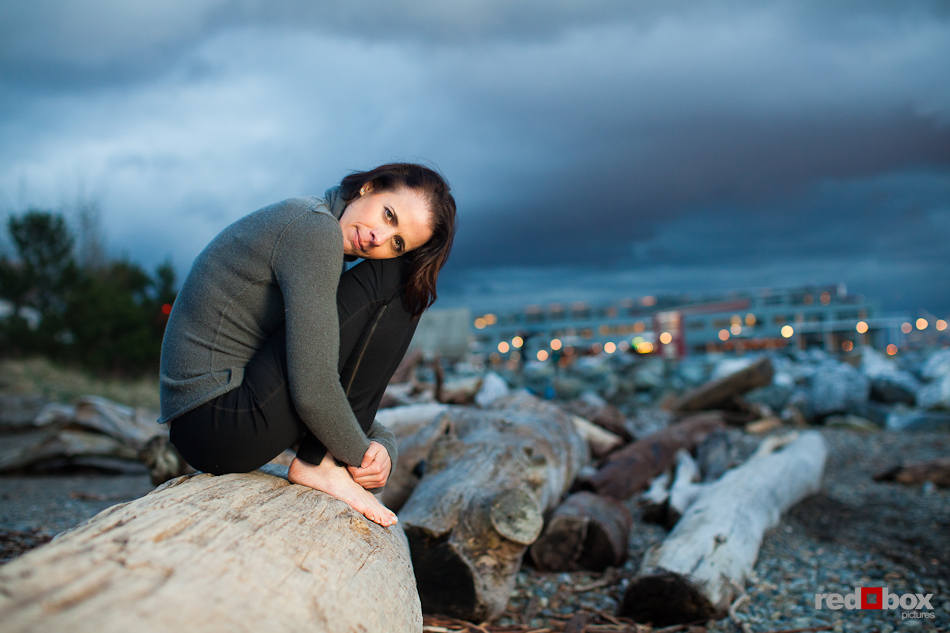 Liz sits atop drift logs while posing for portraits on a Seattle beach a a spring evening. (Photo by Dan DeLong/Red Box Pictures)