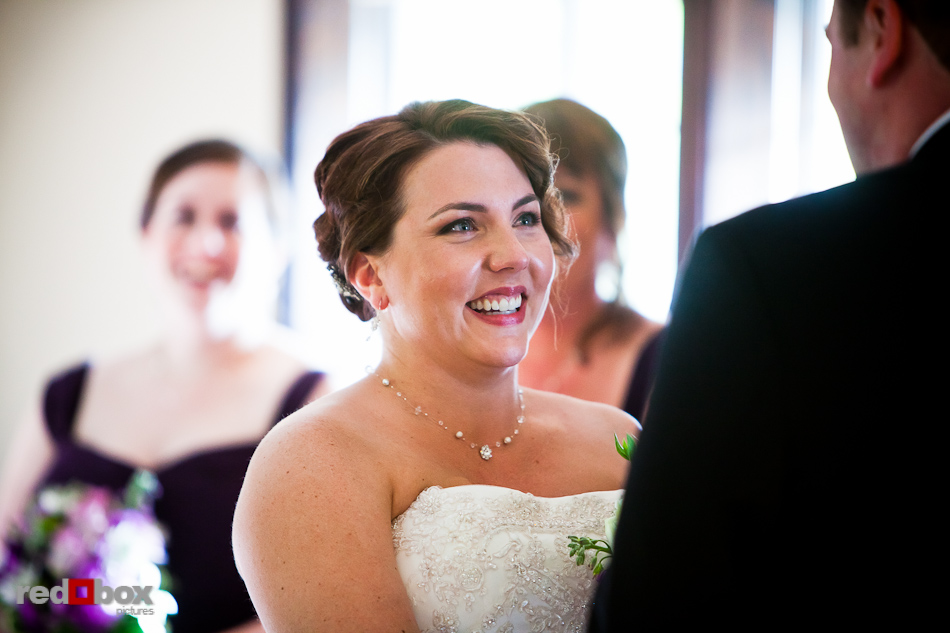 Kari smiles at Matt with tears in her eyes during their wedding ceremony at Courtyard Hall in Bothell. (Photo by Andy Rogers/Red Box Pictures)