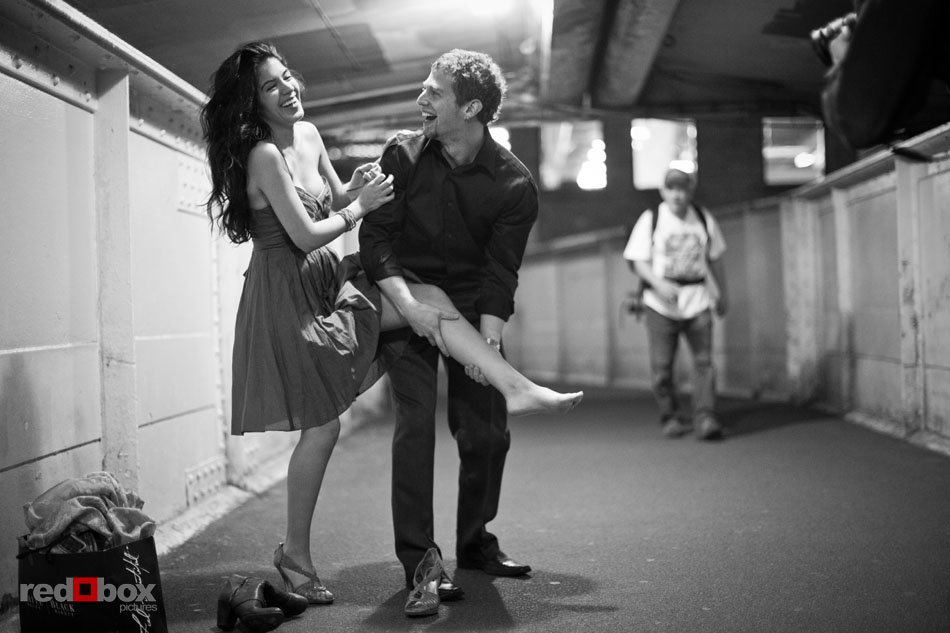 Sharisse laughs as Craig helps her put on shoes after their engagement session in downtown Seattle. (Photos by Dan DeLong/Red Box Pictures)