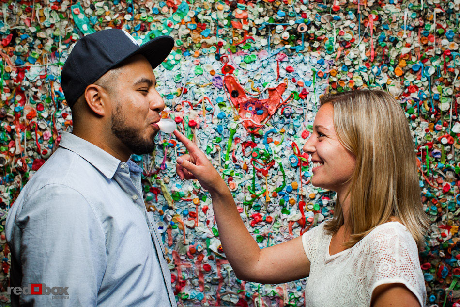 Carlos and Megan have some playful fun during engagement photography session at the Pike Place Market's gum wall in Seattle. (Photo by Dan DeLong/Red Box Pictures)