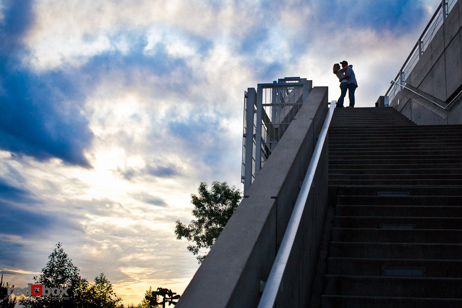 Carlos and Megan kiss against a dramatic sky during their engagement photo sessions at the Olympic Sculpture Park in Seattle. (Photo by Dan DeLong/Red Box Pictures)