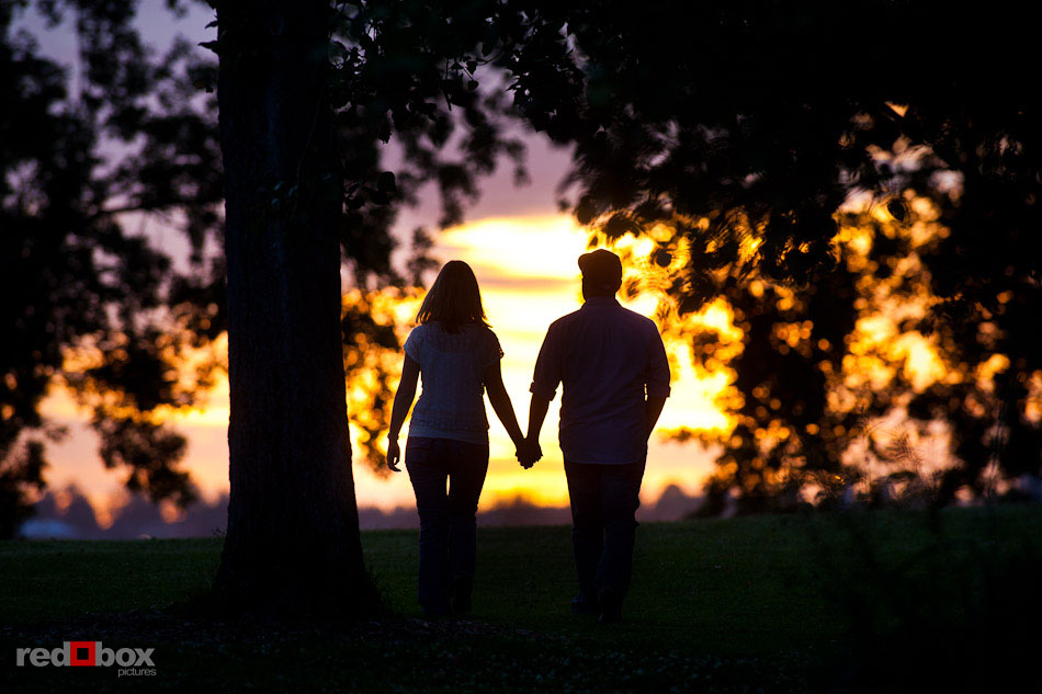 Carlos and Megan are silhouetted by a dramatic Seattle sunset during their engagement photography session at Myrtle Edwards Park. (Photo by Dan DeLong/Red Box Pictures)
