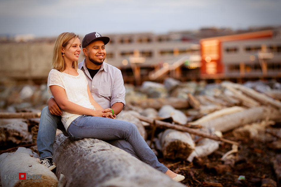 Atop some drift logs, Carlos and Megan watch the sunset from the small beach in the Olympic Sculpture Park in Seattle during their engagement pictures. (Photo by Dan DeLong/Red Box Pictures)