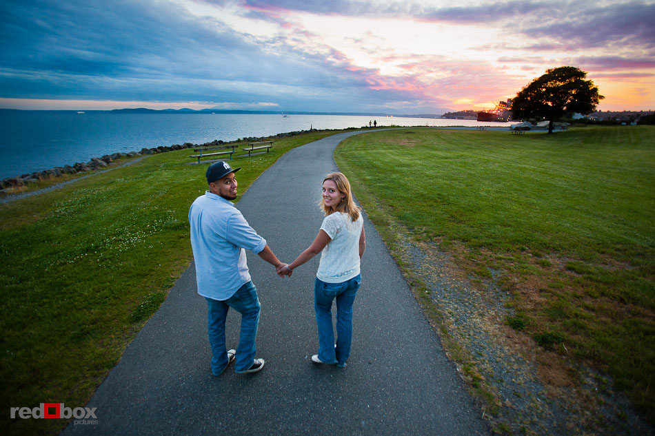 Carlos and Megan walk through Myrtle Edwards Park, on the Seattle waterfront, during their engagement photography session in Seattle. (Photo by Dan DeLong/Red Box Pictures)