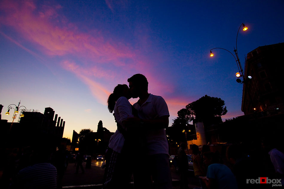 A couple kisses outside the Colosseum in Rome, Italy at sunset. (Photography By: Scott Eklund/Red Box Pictures)