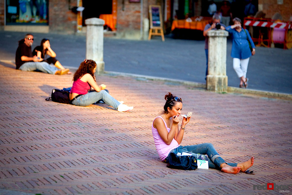 A girl checks our her make-up in the Piazza del Campo in Siena, Tuscany, Italy. (Italy Photography By Scott Eklund/Red Box Pictures)