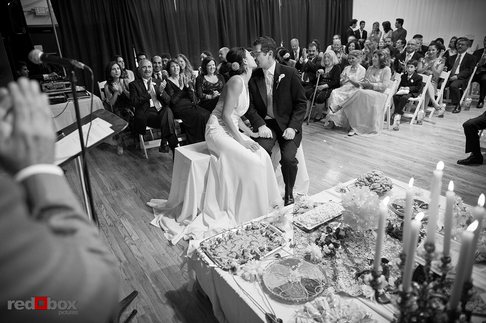 Sitting in front of the Sofreh, Jane and Kia kiss during the Persian wedding ceremony at Velocity Dance Center in Seattle. (Photo by Andy Rogers/Red Box Pictures)