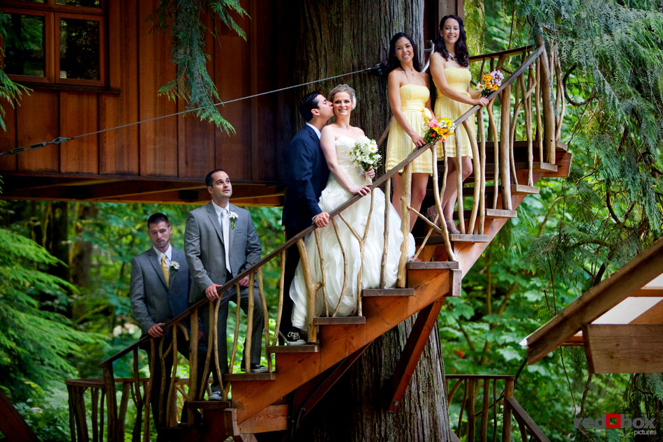 The bride and groom and wedding party stand for a portrait on the stairs leading up to one of the treehouses at Treehouse Point in Issaquah, Wash. (Seattle Wedding Photographer Scott Eklund/Red Box Pictures)