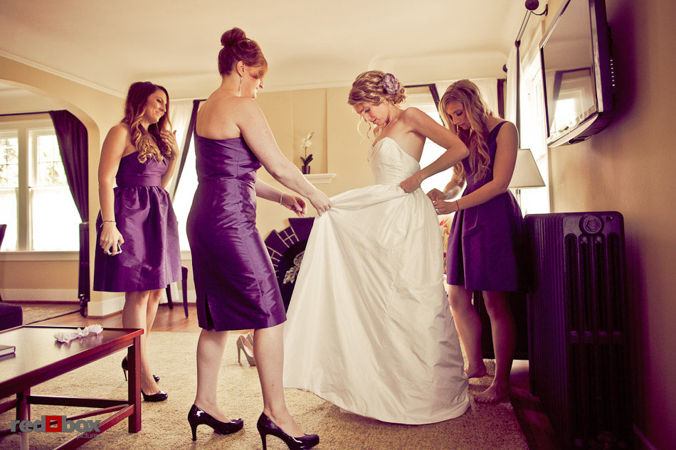 Her bridesmaids help Amanda put on her wedding dress at Chelsea Station in Seattle.  (Photo by Dan DeLong/Red Box Pictures)