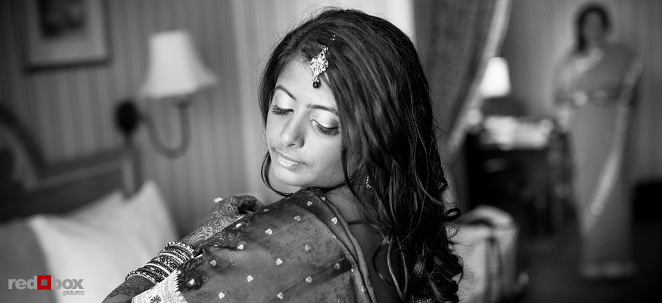 Poonam puts on her sari as she gets ready at Hotel Monaco prior to her Pravda Studio wedding in Seattle. (Photo by Andy Rogers/Red Box Pictures)