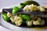 Shaved squid with spring fava beans enrobed in an ink sheet at Lampreia Restaurant in Seattle. (Photographer: Scott Eklund)