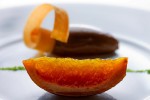 Orange confit with chocolate caramel mousse and ground pistachio at Lampreia Restaurant in Seattle. (Photographer: Scott Eklund)
