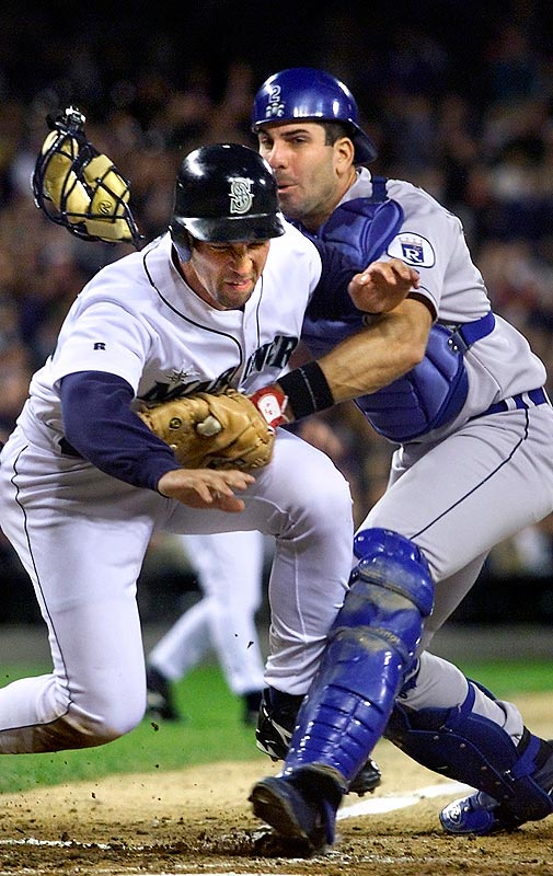 Raul Ibanez scores despite a collision with Jorge Fabregas at home plate. (Photographer: Andy Rogers)