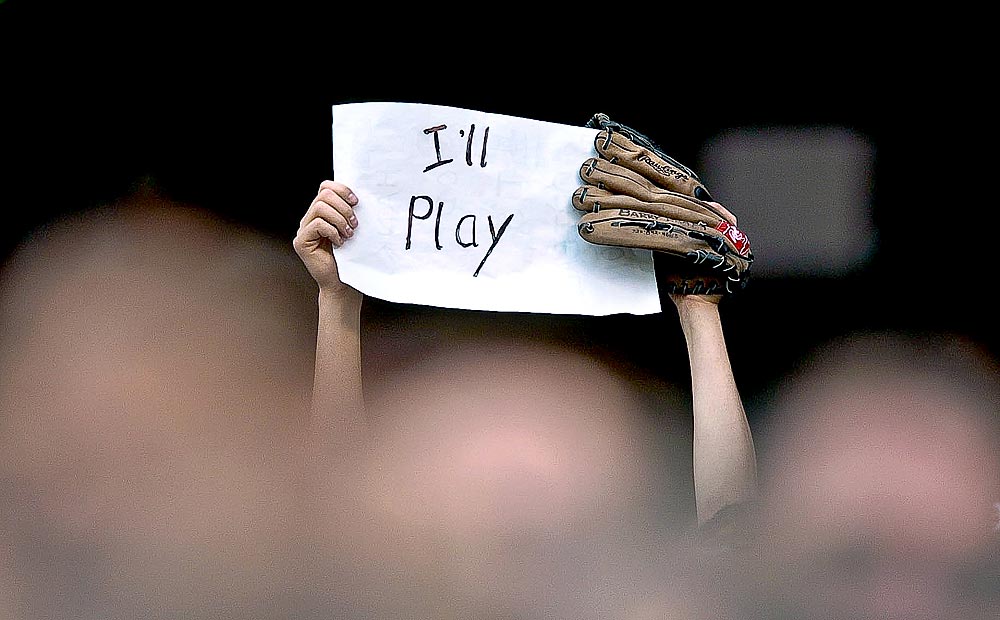 A young fan holds a sign protesting a potentential Major League Baseball strike during a Rockies game in Denver . (Photographer: Andy Rogers)