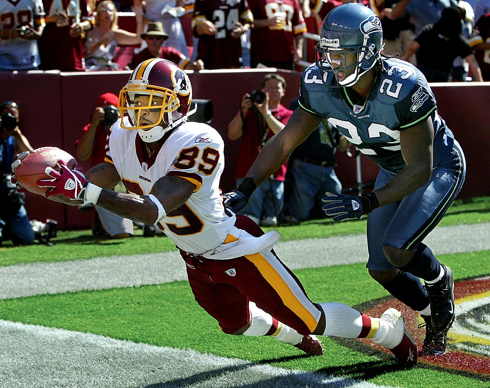 Redskins' receiver Santana Moss toes the line as he hauls in an apparent touchdown in front of Seahawks defender Marcus Trufant. But referees said the ball touched the ground when he fell. (Photographer: Scott Eklund)