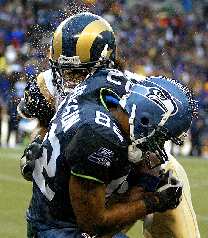 Seahawks wide receiver Darrell Jackson can't hold on to the ball as he gets drilled by Rams defender Corey Chavous. (Photographer: Scott Eklund)