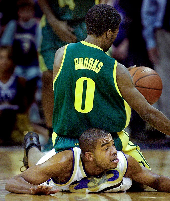 Washington's Joel Smith gets tangled up with Oregon's Aaron Brooks while going for a steal. (Photographer: Scott Eklund)
